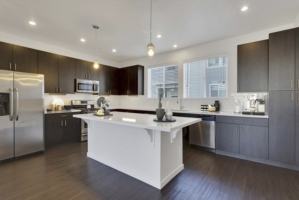 a large kitchen with a white island and stainless steel appliances