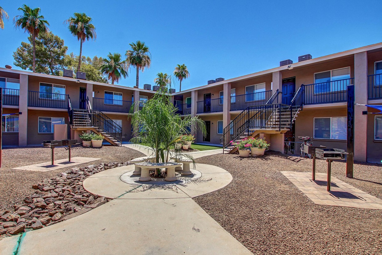 a courtyard with a fountain and palm trees in front of a building