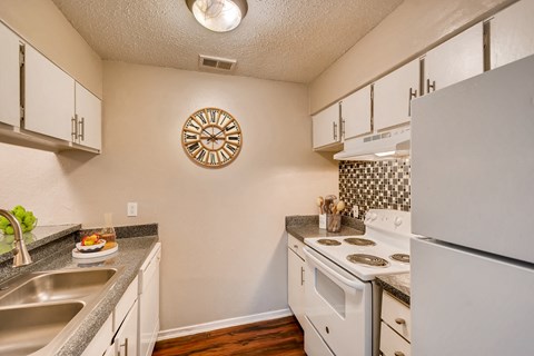 a kitchen with white appliances and granite counter tops