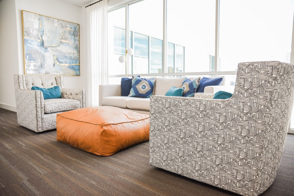 a living room with couches and chairs and a large window