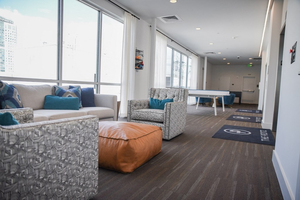 a living room with couches and chairs and a ping pong table