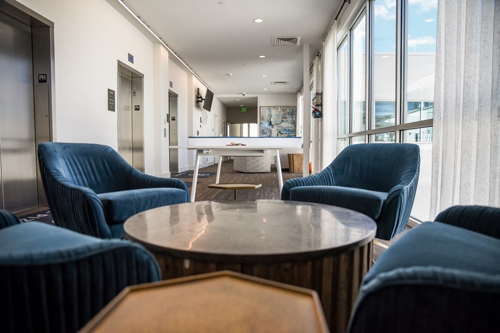 a lounge area with blue chairs and a table