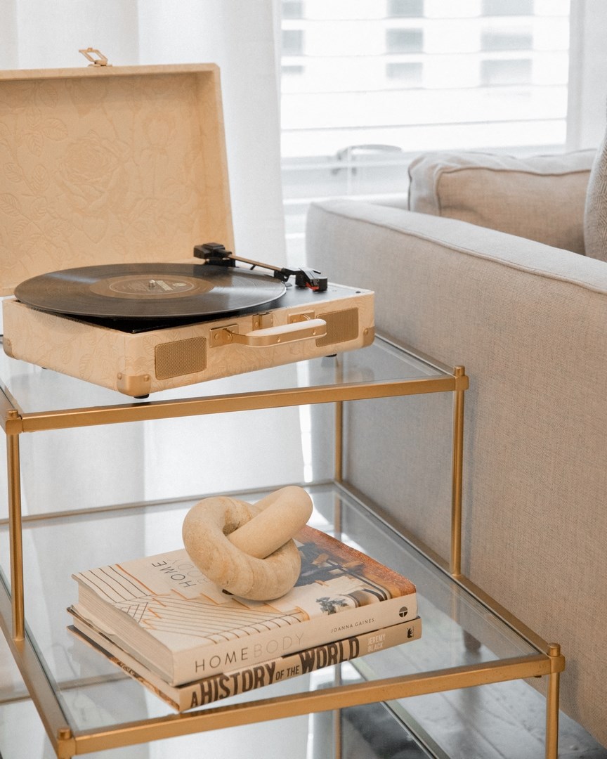 a living room with a glass coffee table with a turntable on it
