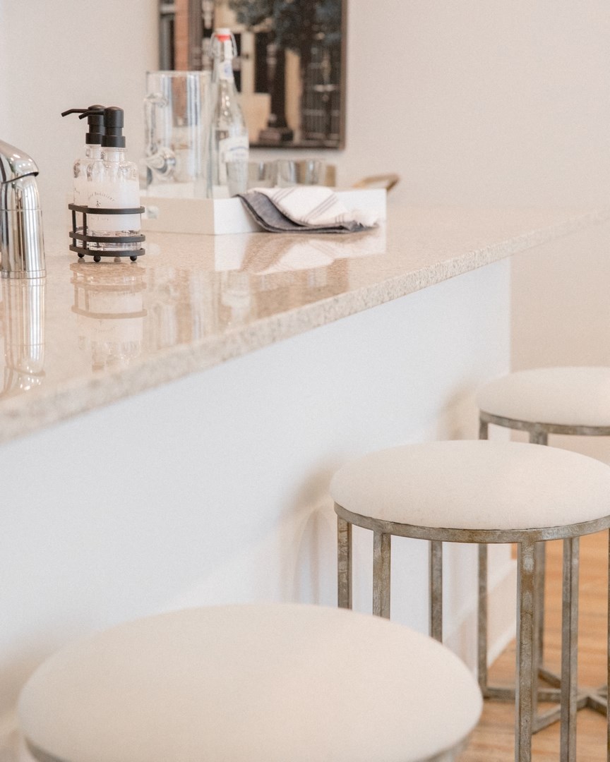 a row of stools in front of a counter in a kitchen