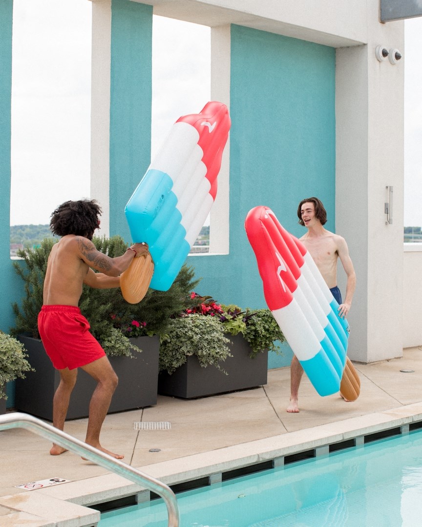 two men are standing next to a swimming pool