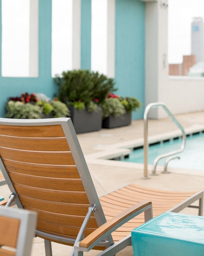 a lounge chair next to a pool in a hotel room