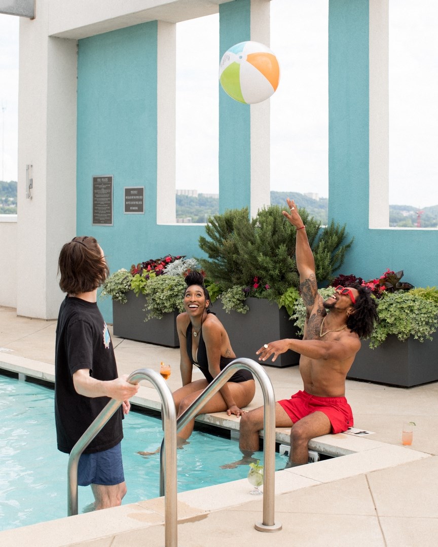 a group of men in a pool playing with a beach ball