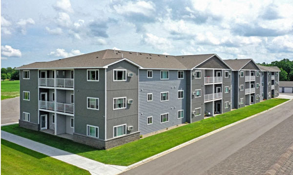 a rendering of an apartment building on the side of a road