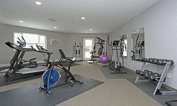 a gym with exercise equipment and mirrors on the wall