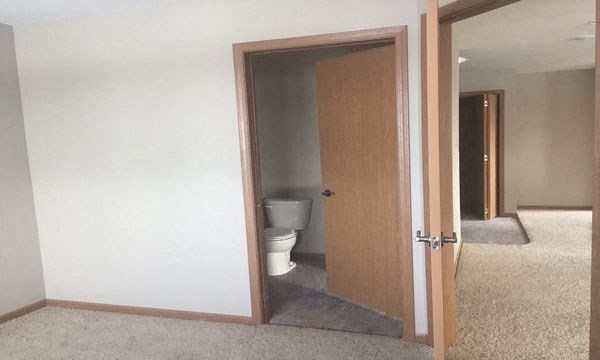 an open door to a bathroom with a toilet