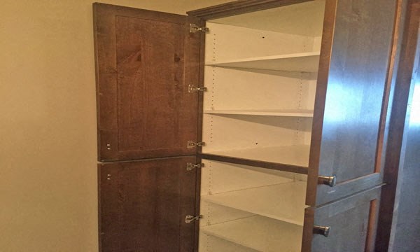 a closet with shelves and a wooden door