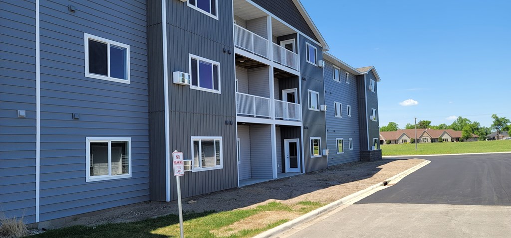 a new apartment building with blue siding and a street