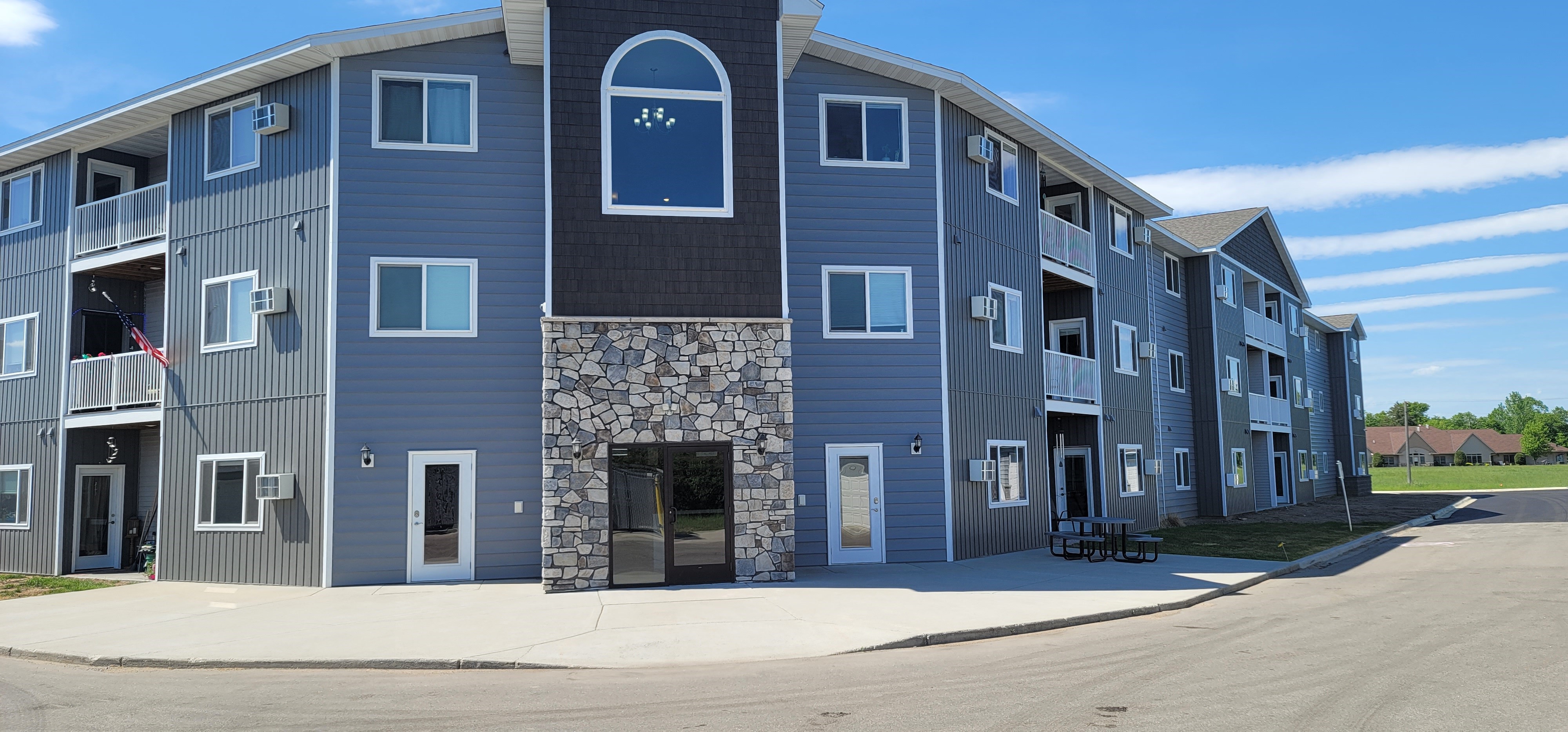 an apartment building with a blue exterior and stone facade