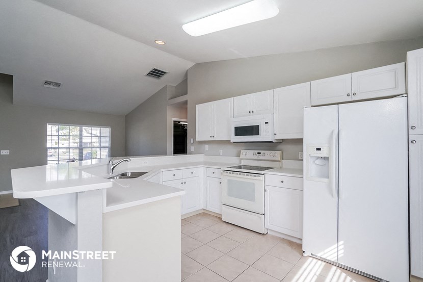 a white kitchen with white appliances and white counters