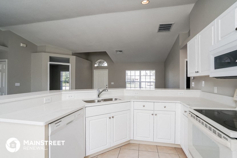 a large white kitchen with white cabinets and a sink