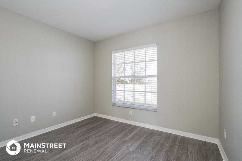 the interior of an empty room with wooden floors and a window