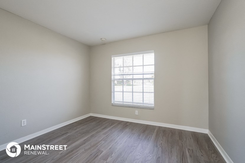 the interior of an empty room with wooden floors and a window