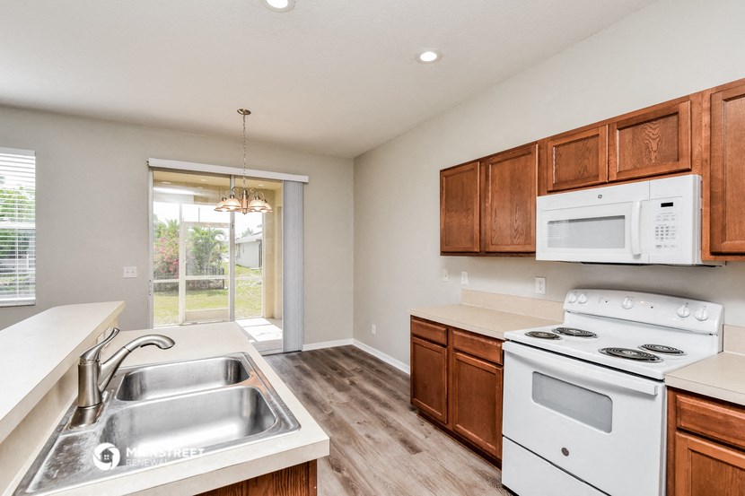 a kitchen with white appliances and wooden cabinets