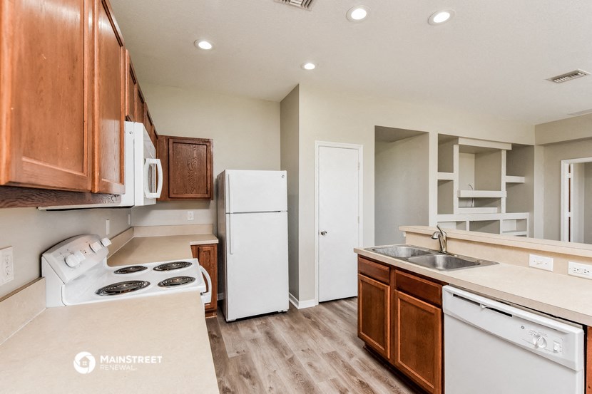 a kitchen with white appliances and wooden cabinets
