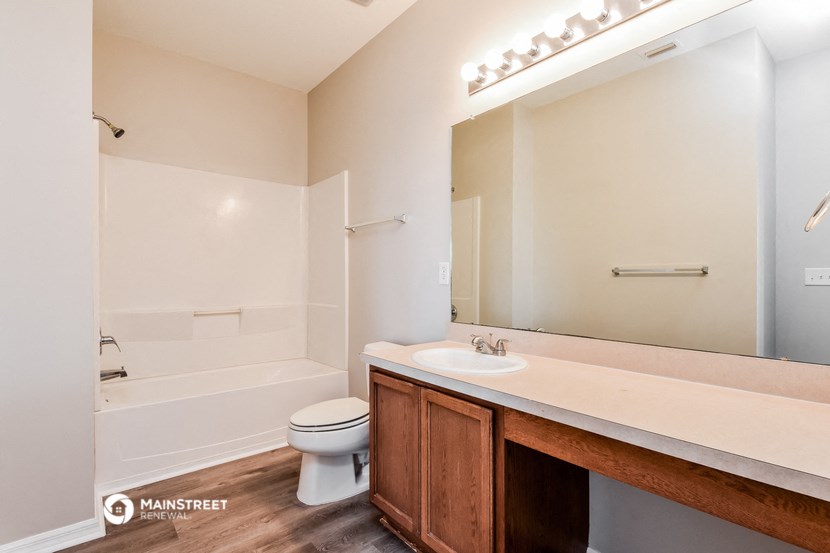 a bathroom with a large mirror and a toilet and a sink