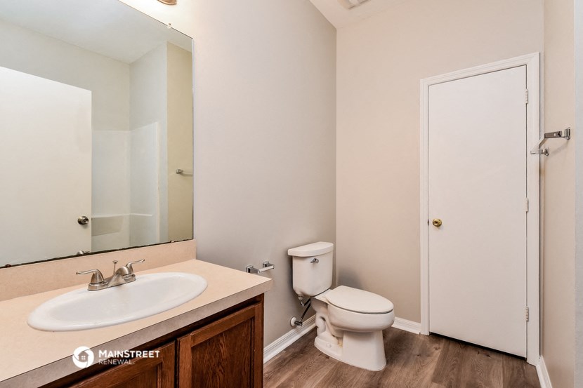 a bathroom with a mirror and a toilet and a sink