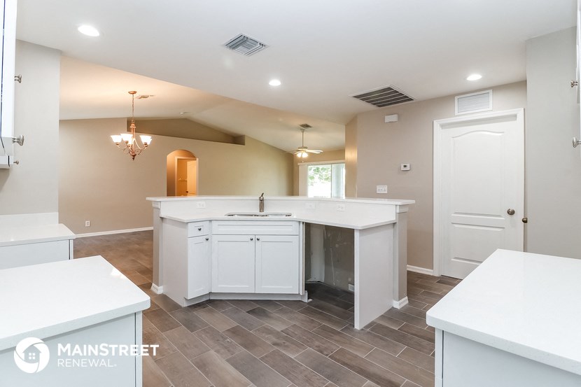 a large kitchen with white cabinets and a white counter top