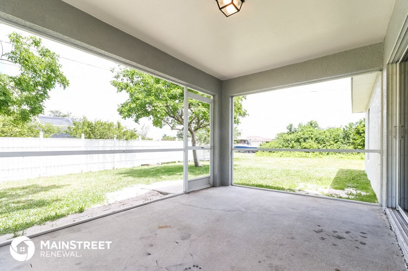 a patio with a view of a yard and a large glass door