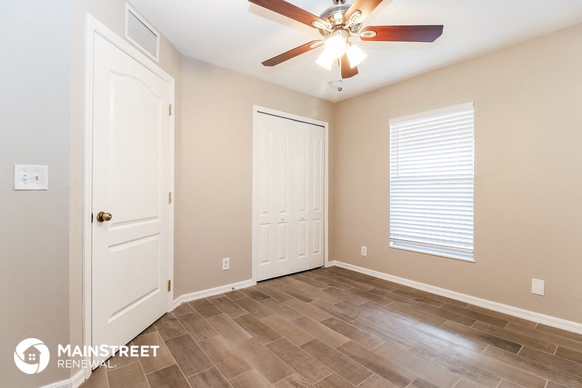 a bedroom with a ceiling fan and a door