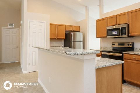 a kitchen with granite counter tops and wooden cabinets