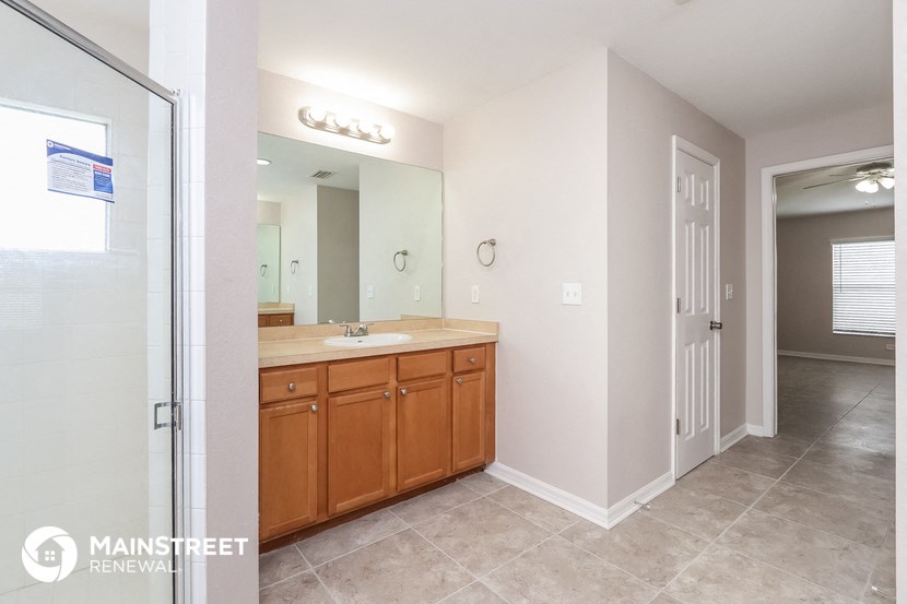 the master bathroom has a large vanity and a shower