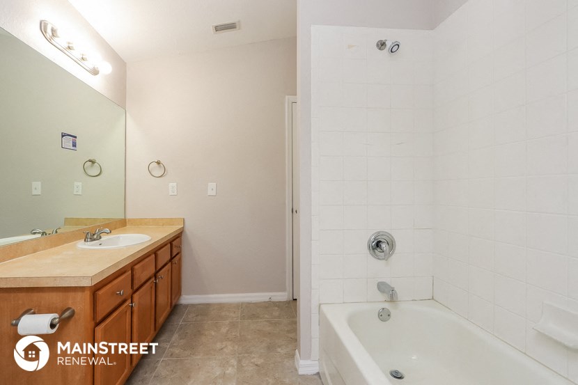 a bathroom with a tub and a sink and a mirror
