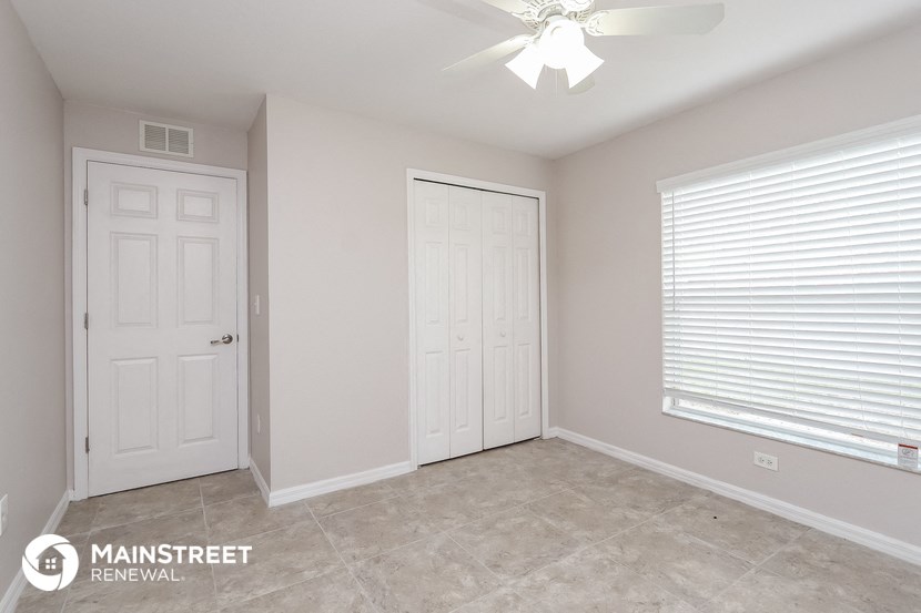 the master bedroom has a large window and tile flooring