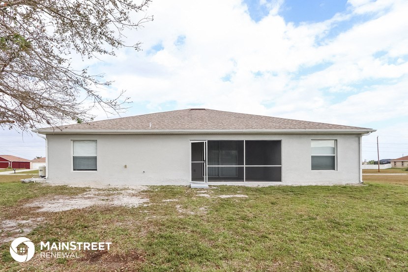 a small white house with a lawn and a tree
