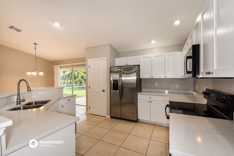 the kitchen has stainless steel appliances and white cabinets