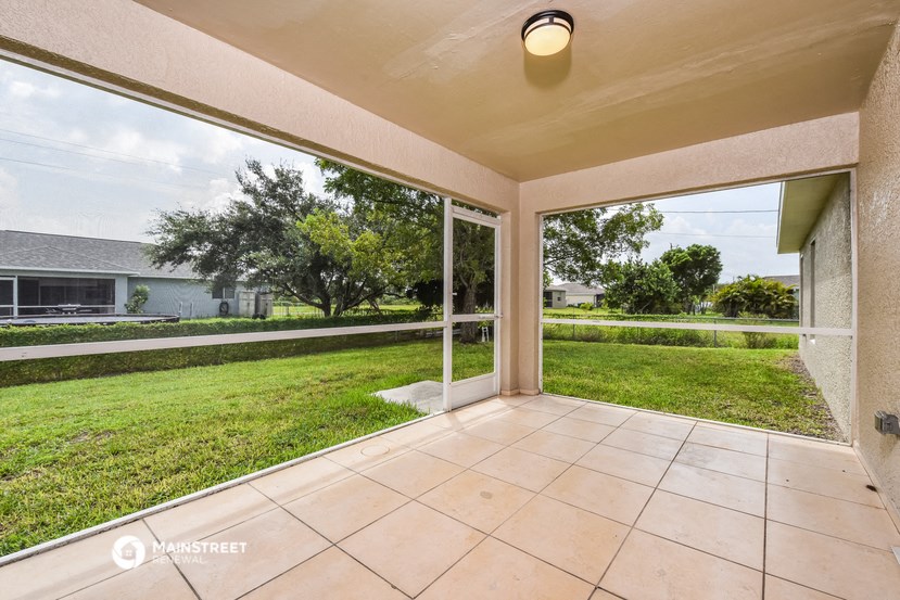 a covered patio with a view of the yard and grass