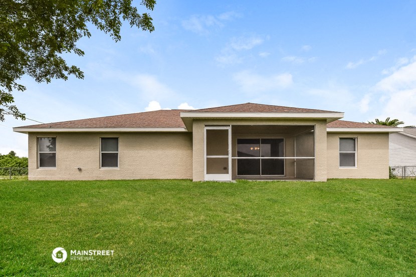 front view of a house with a lawn and a tree