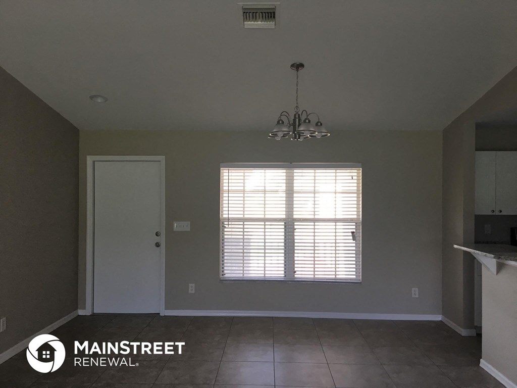a kitchen with a window and a door and a chandelier