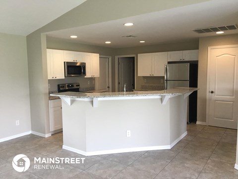 an updated kitchen with white cabinets and a counter top