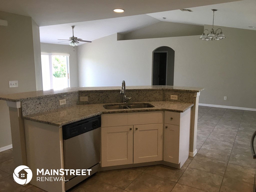 an empty kitchen with a sink and a counter top