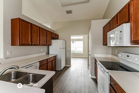a kitchen with white appliances and wooden cabinets
