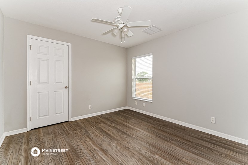 the living room of an empty house with a ceiling fan