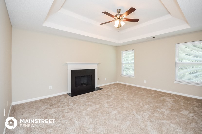 the living room with fireplace and ceiling fan