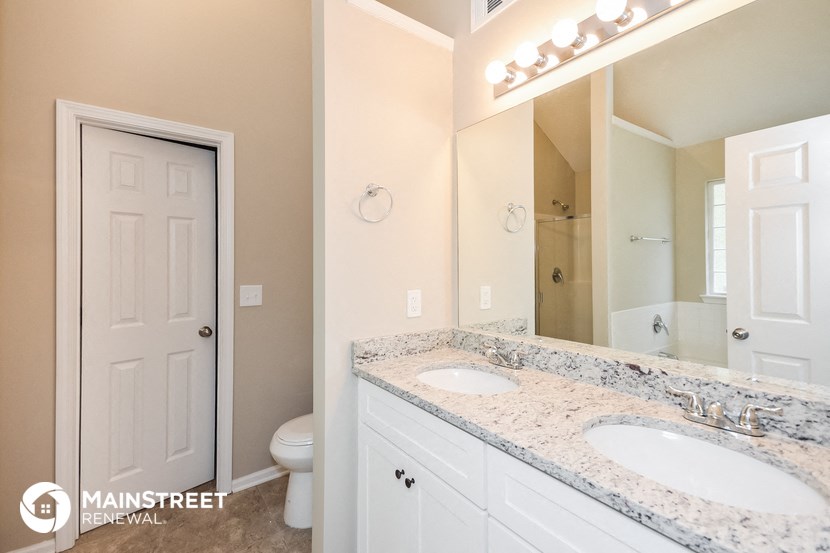 a bathroom with two sinks and a mirror and a toilet