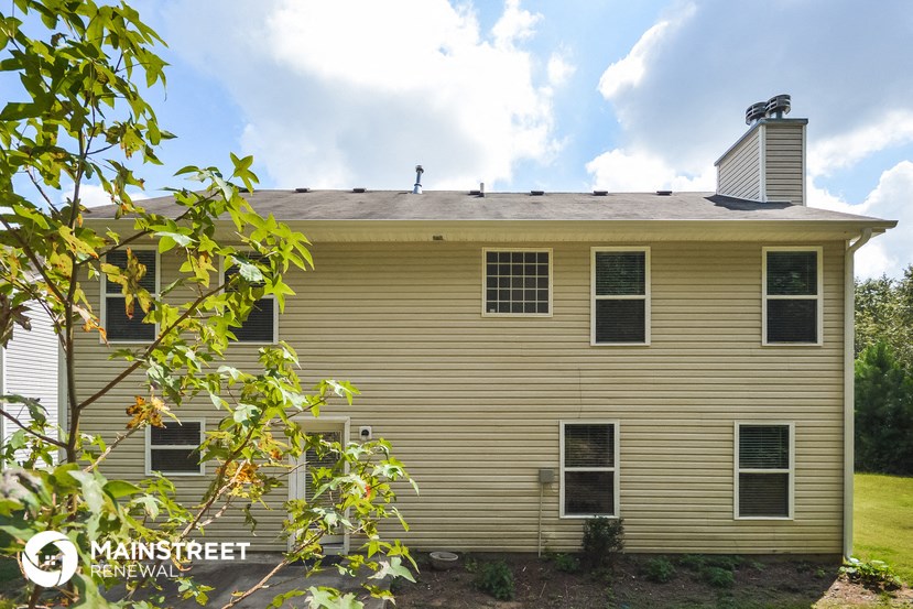 a yellow house with a tree in front of it