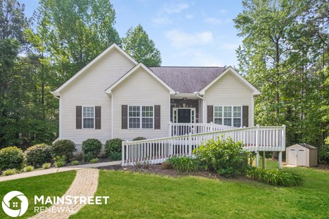 a white house with a white porch and a white fence