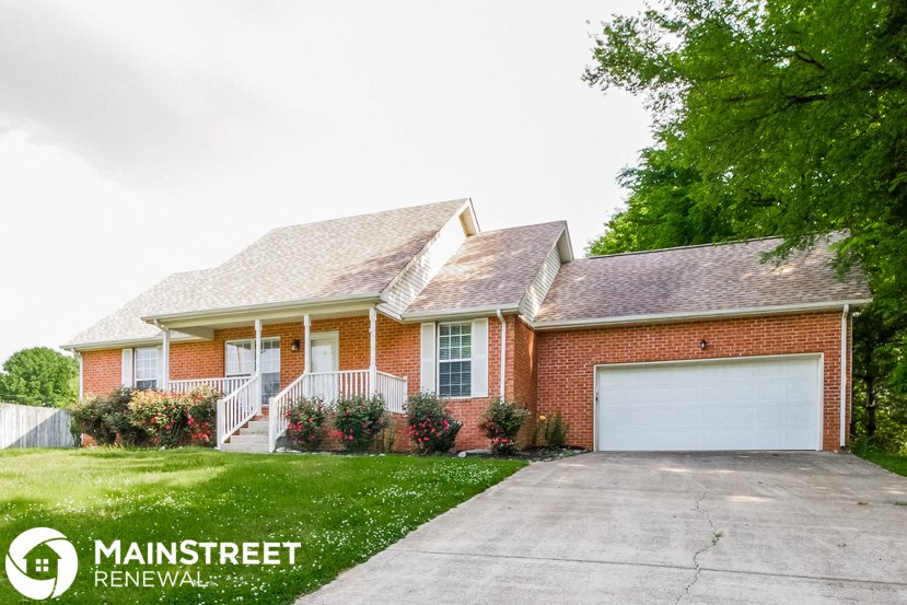 a house with a driveway and a garage door in front of it