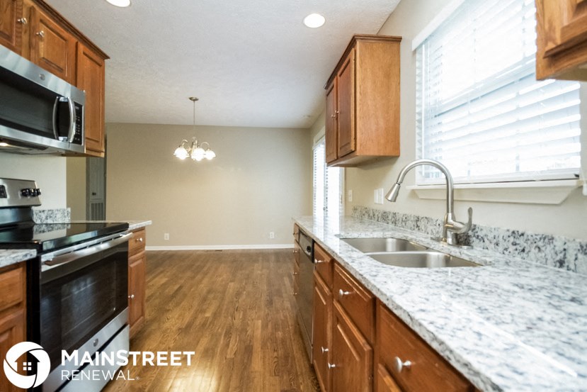 a kitchen with granite counter tops and wooden cabinets and a sink