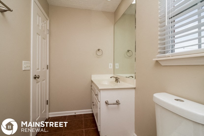 a bathroom with a toilet and a sink and a mirror