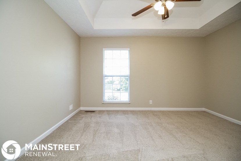 a empty room with a ceiling fan and a window