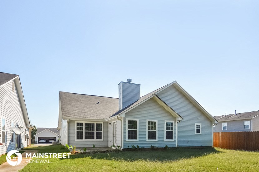a white house with a gray roof and a blue sky